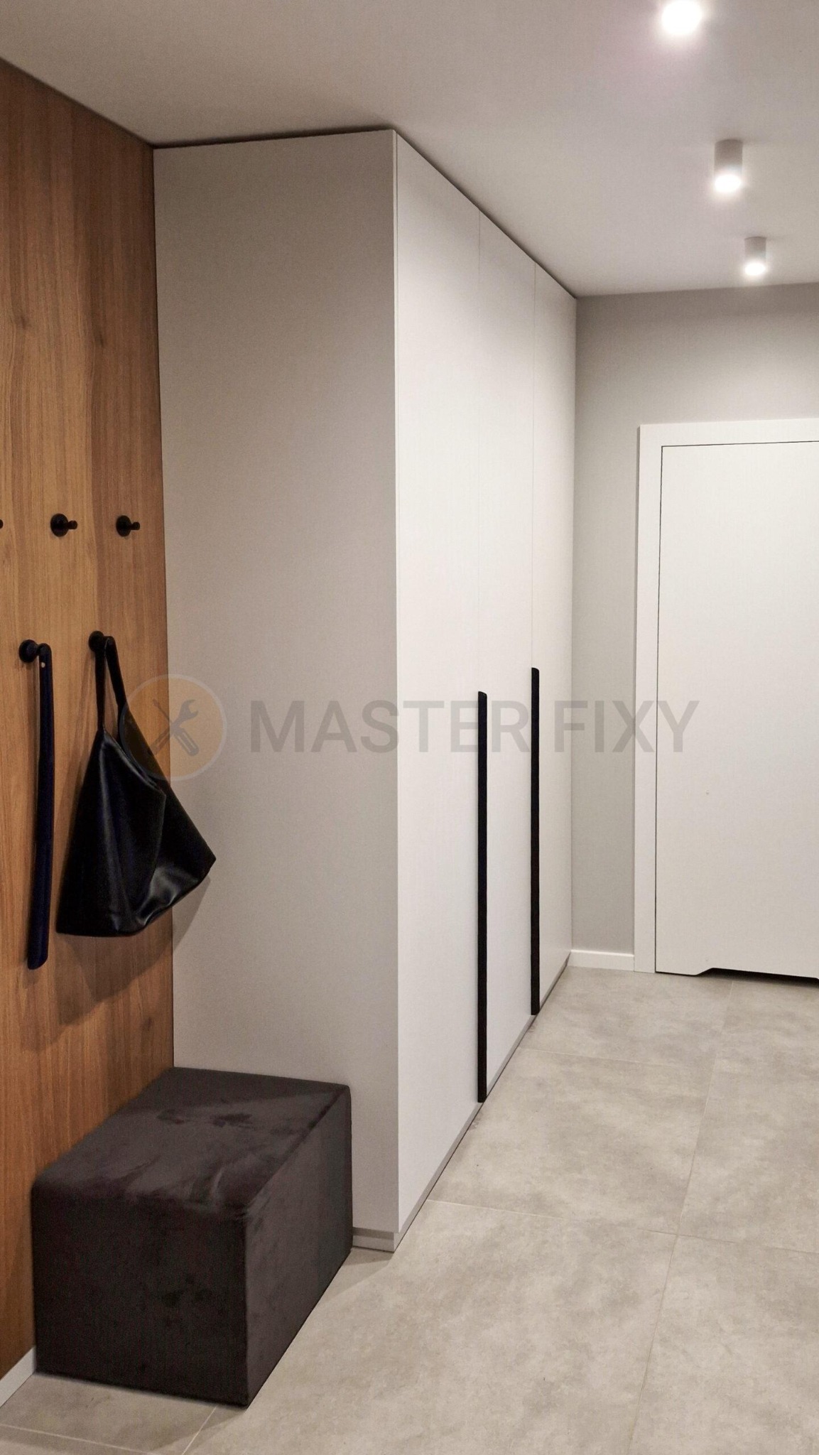 Przedpokój z masywną szafą, szarościową płytką i drewnianymi panelami