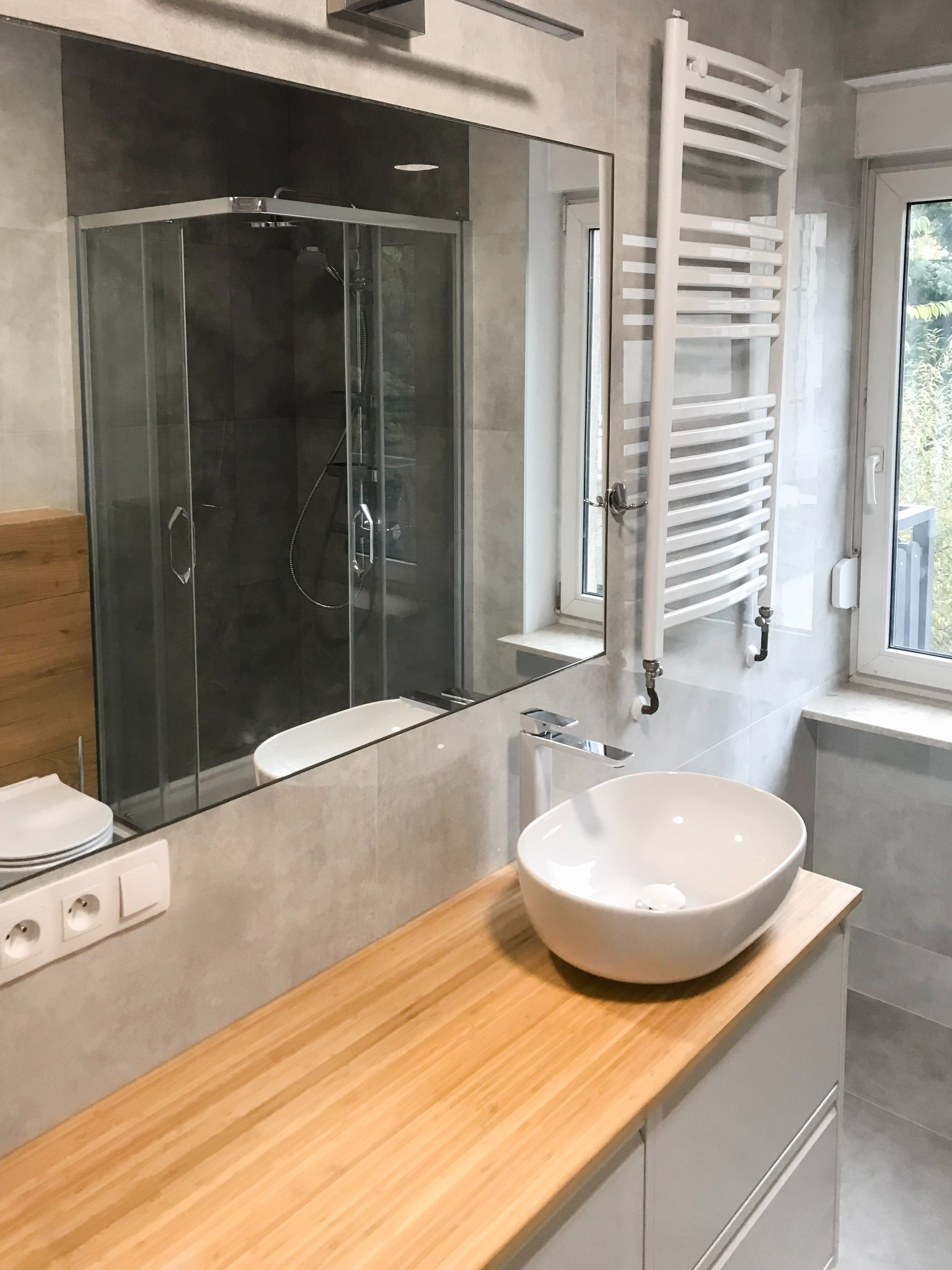 Łazienka z szaro-srebrną płytką i wbudowaną umywalką w meble