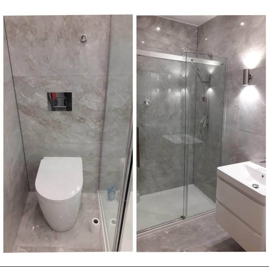 Nowoczesna łazienka z szarymi płytkami imitującymi marmur, kabina prysznicowa ze szklanymi drzwiami przesuwnymi, podwieszana toaleta i umywalka z szafką, oświetlenie punktowe w suficie i kinkiet...