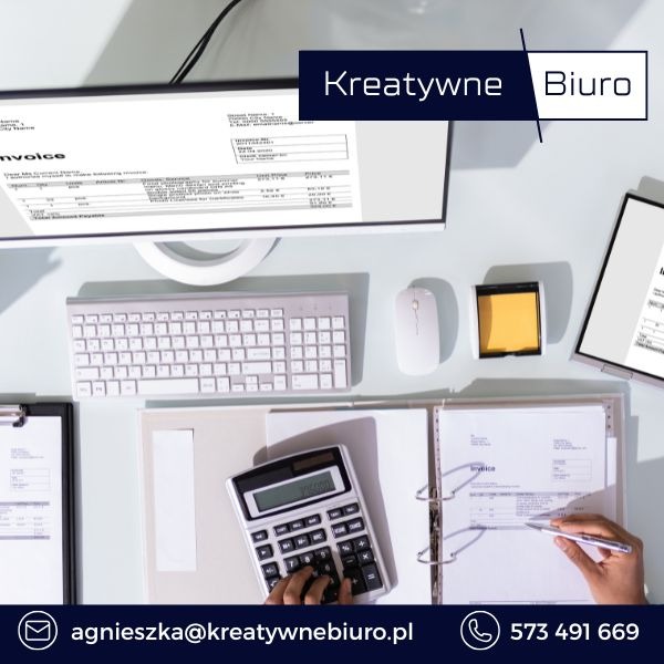 Biurko z monitorem wyświetlającym fakturę, klawiaturą, myszką, kalkulatorem, notatkami i dłonią wypełniającą dokument, oświetlone jasnym światłem