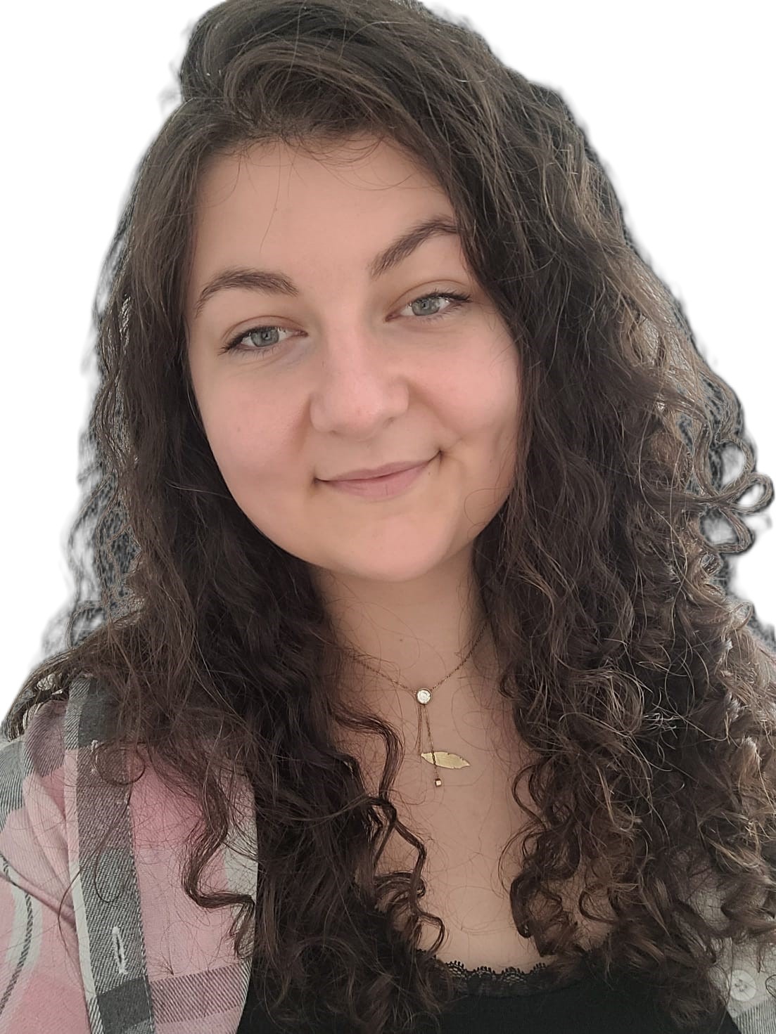 Portret uśmiechniętej kobiety z kręconymi, brązowymi włosami, noszącej złotą biżuterię i koszulę w różową kratę.