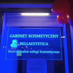 Mangraf Studio - Podświetlany szyld gabinetu kosmetycznego Bellaestetica z logo i napisem Profesjonalne usługi kosmetyczne, udekorowany czerwonymi balonami.