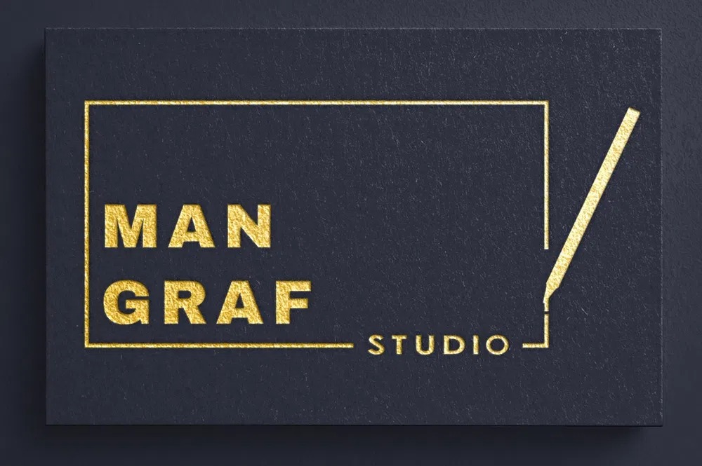 Elegancka, czarna wizytówka z tłoczonym złotym napisem 'MAN GRAF STUDIO' i minimalistycznym symbolem ołówka w obrysie prostokąta.