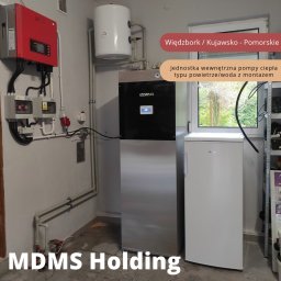 MDMS HOLDING Spółka z o.o. - Zainstalowana jednostka wewnętrzna powietrznej pompy ciepła Izzifast w kotłowni, widoczny również zbiornik buforowy, rozdzielnia elektryczna z falownikiem i zabezpieczeniami, oraz fragment...