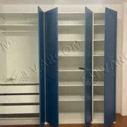 Niebiesko-biała szafa na wymiar z otwartymi drzwiami, widoczne półki i szuflady, zamontowana w mieszkaniu w Krakowie.