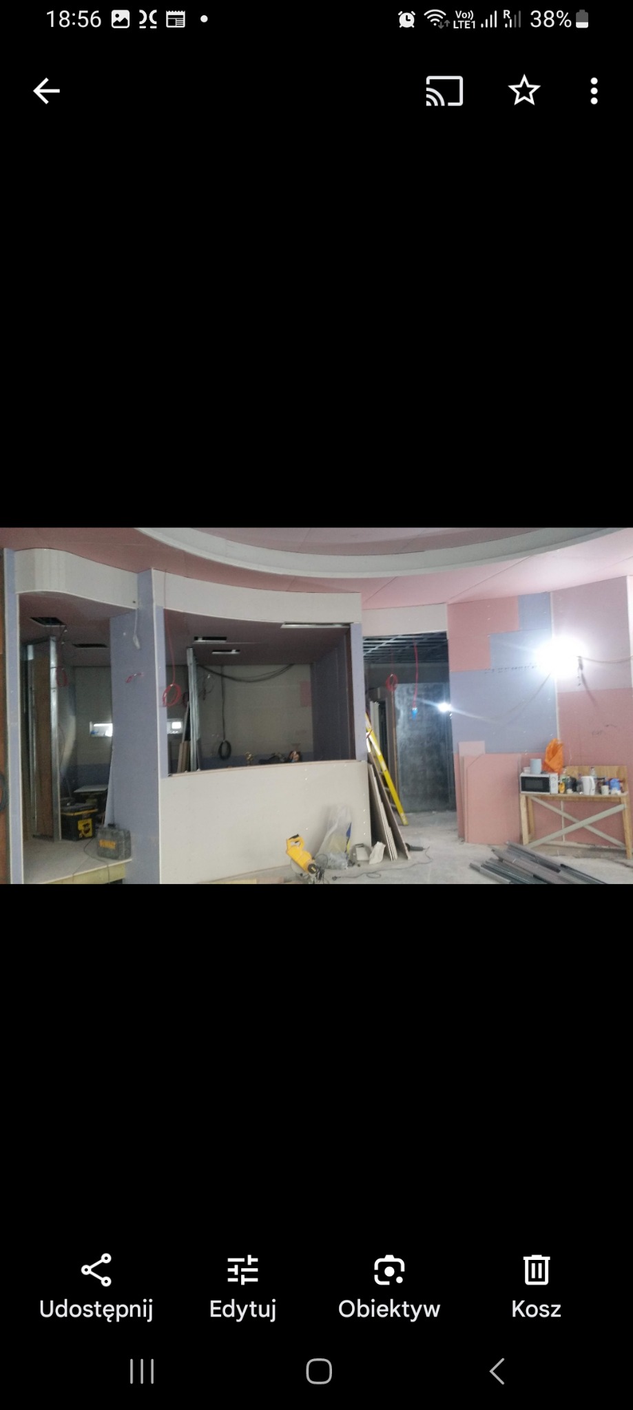 Wnętrze w trakcie montażu ścianek działowych z płyt kartonowo-gipsowych, widoczne narzędzia i materiały budowlane, sufit z dekoracyjnymi elementami.