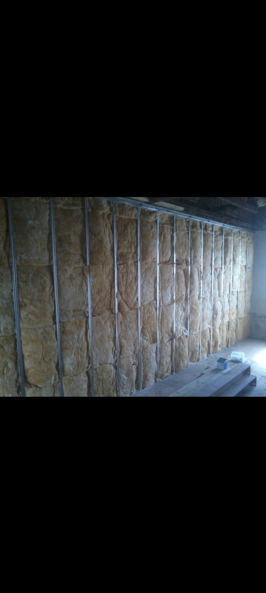 Ściana z metalowym stelażem wypełnionym wełną mineralną, widoczne przygotowania do montażu płyt.