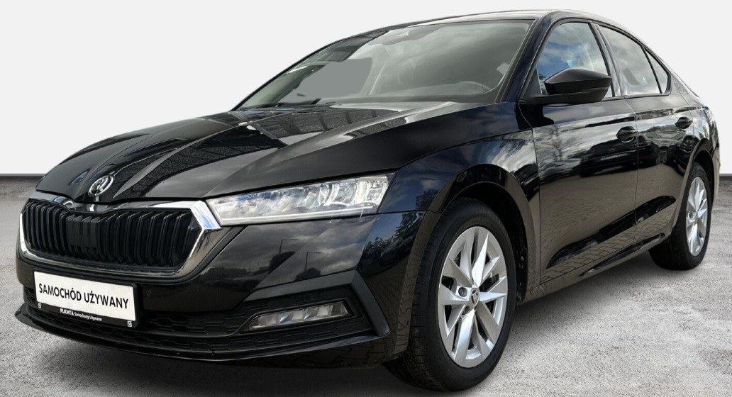 Czarna Skoda Octavia, widok z przodu, na tabliczce napis 'Samochód używany'.