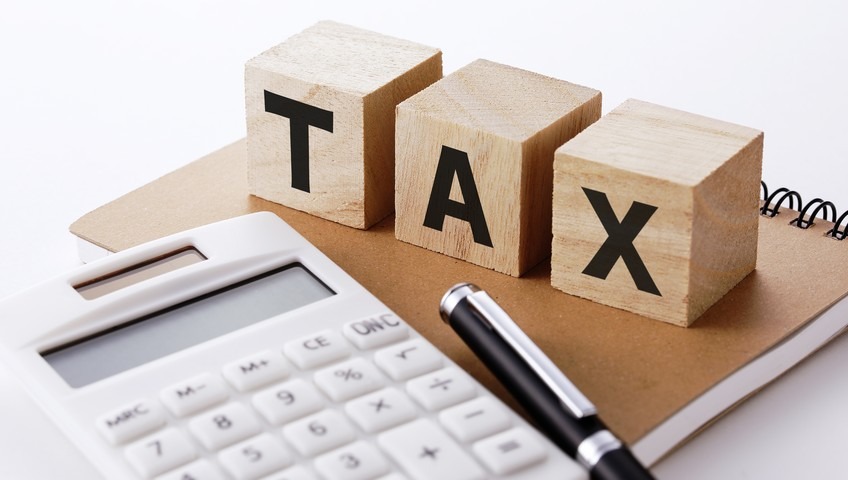 Kalkulator, notatnik i kostki z napisem TAX w Wieruszowie. Narzędzia pracy doradcy podatkowego lub księgowego. Usługi finansowe dla firm i osób prywatnych.