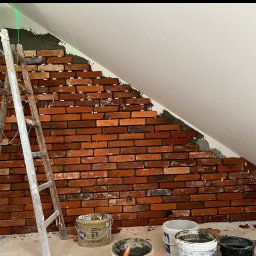 Aleksander Smoleń VentiPRO - Układanie cegieł na ścianie pod skosem, widoczne poziomice laserowe, drabina i wiadra z zaprawą. Cegły w odcieniach czerwieni i brązu, białe fugi. Prace wykończeniowe.