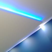 Abstrakcyjne ujęcie narożnika ściany z oświetleniem LED w kolorze niebieskim, tworzące nowoczesny i minimalistyczny efekt wizualny. Kontrast kolorów i faktur.