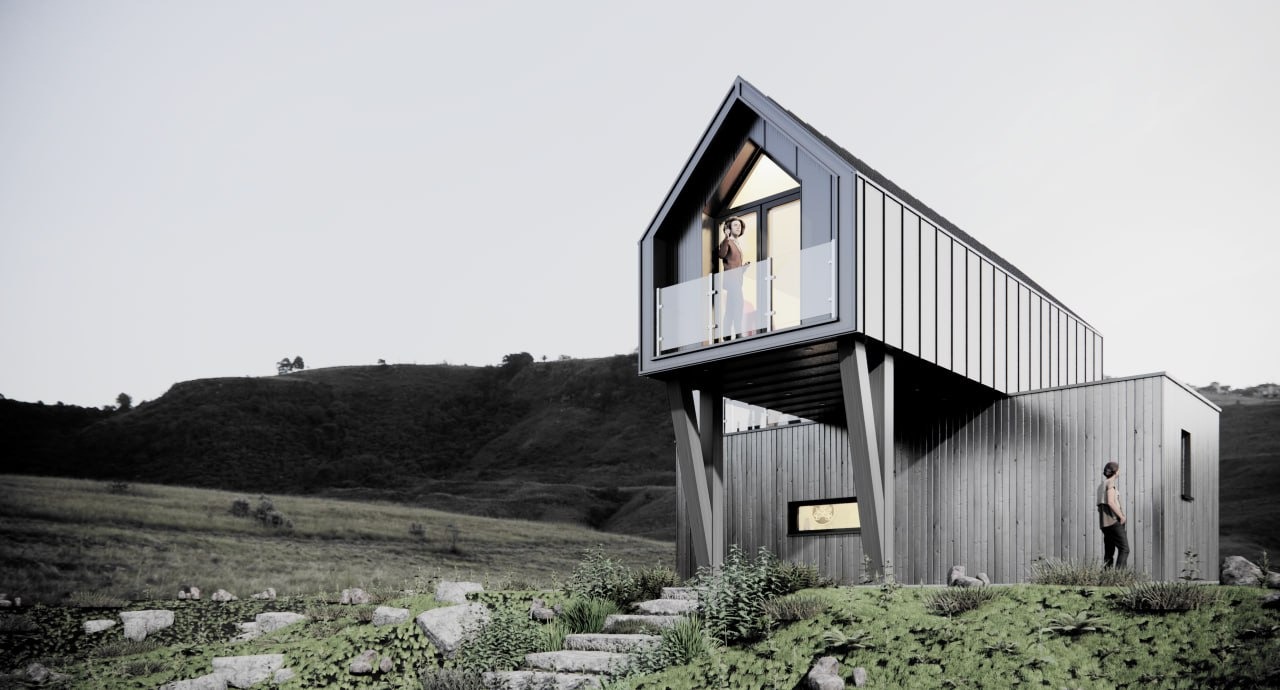 Nowoczesny dom z ciemnego drewna na zboczu wzgórza, z balkonem i dużymi oknami, otoczony zielenią i kamiennymi schodami.