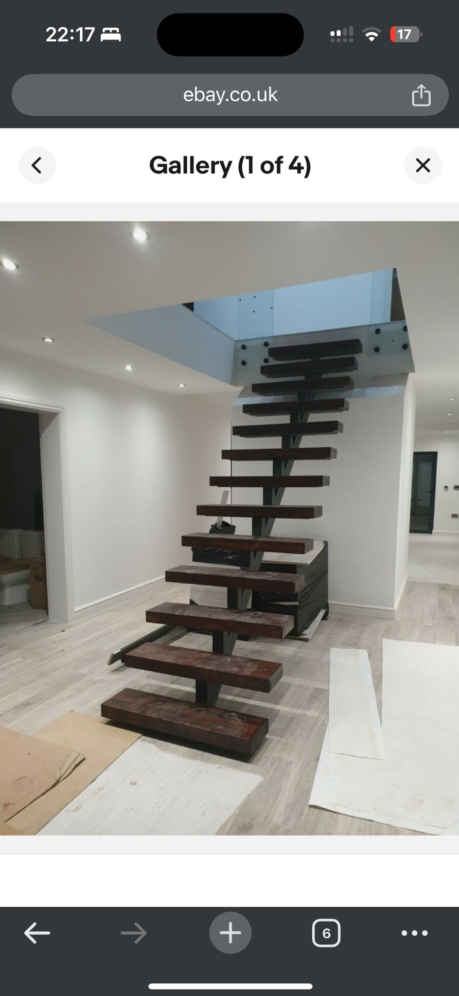 Nowoczesne schody metalowe z drewnianymi stopniami, zawieszone w przestrzeni, z widocznymi mocowaniami do sufitu. Minimalistyczny design w jasnym wnętrzu.