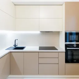 Nowoczesna kuchnia z beżowymi szafkami, czarnym zlewem i sprzętem AGD marki Bosch, oświetlona listwami LED pod górnymi szafkami.