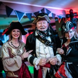 Agencja Turystyczno-Artystyczna Przygoda Anna Gołębiowska-Rusak - Trzy osoby przebrane w stroje pirackie podczas tematycznego przyjęcia, widoczne dekoracje i nagłośnienie.