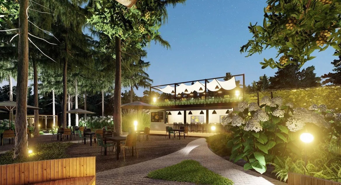 Dwupoziomowa restauracja z zewnętrznym tarasem otoczona drzewami i kwitnącymi krzewami hortensji, oświetlona lampami ogrodowymi i girlandami, z ścieżką z kostki brukowej i drewnianą ławką...