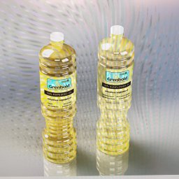 KUMASZPRO Dariusz Ćwiklak - Dwie plastikowe butelki z olejem roślinnym marki Grenhold, jedna z olejem rzepakowym, druga ze słonecznikowym, stojące na błyszczącej powierzchni z refleksami.