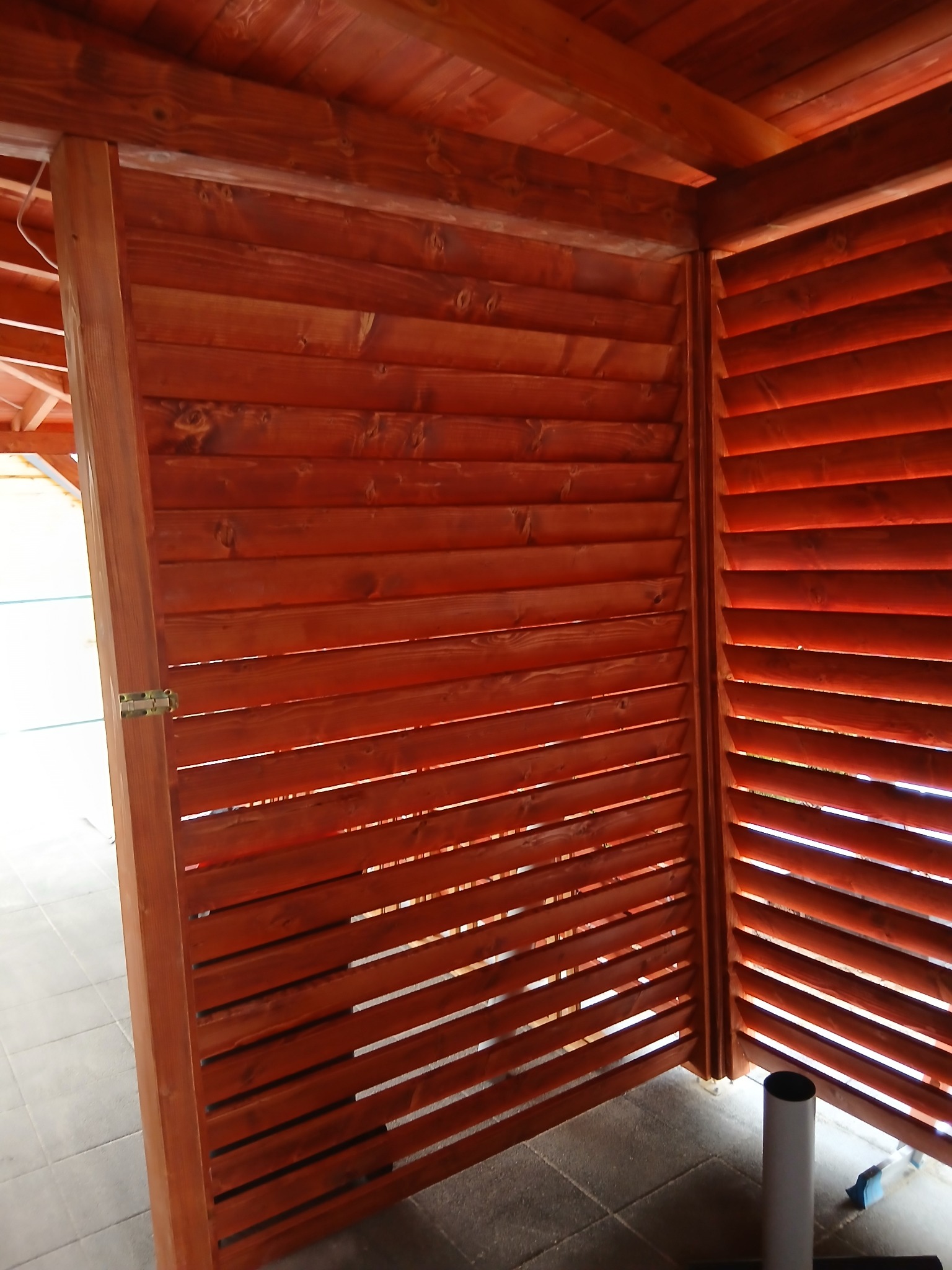 Drewniana zabudowa z lameli w odcieniach brązu, wykonana w Grybowie. Widoczny fragment zamykanej konstrukcji, detale wykończenia i naturalna faktura drewna.