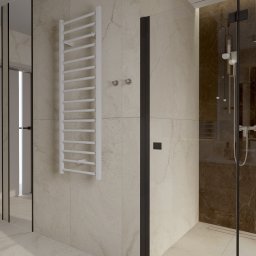 Karolina Szczesna Wnętrza - Nowoczesna łazienka z beżowymi płytkami imitującymi marmur, kabiną prysznicową typu walk-in z ciemnymi profilami, białym grzejnikiem drabinkowym i minimalistycznymi akcesoriami.