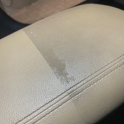 ISS - Studio Auto Detailingu Kevin Kaczmarek - Fragment jasnej, skórzanej tapicerki samochodowej, widoczna różnica w czystości po praniu na fragmencie powierzchni.