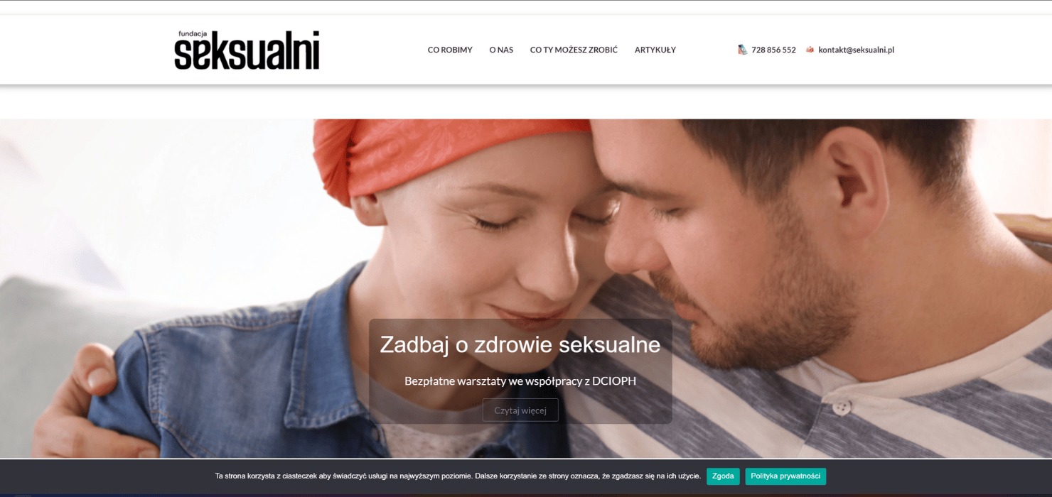 Zdjęcie z nagłówka strony internetowej fundacji 'seksualni.pl' przedstawia parę w czułym uścisku, kobieta z pomarańczową chustą na głowie, mężczyzna z krótkim zarostem, oboje patrzą w dół.