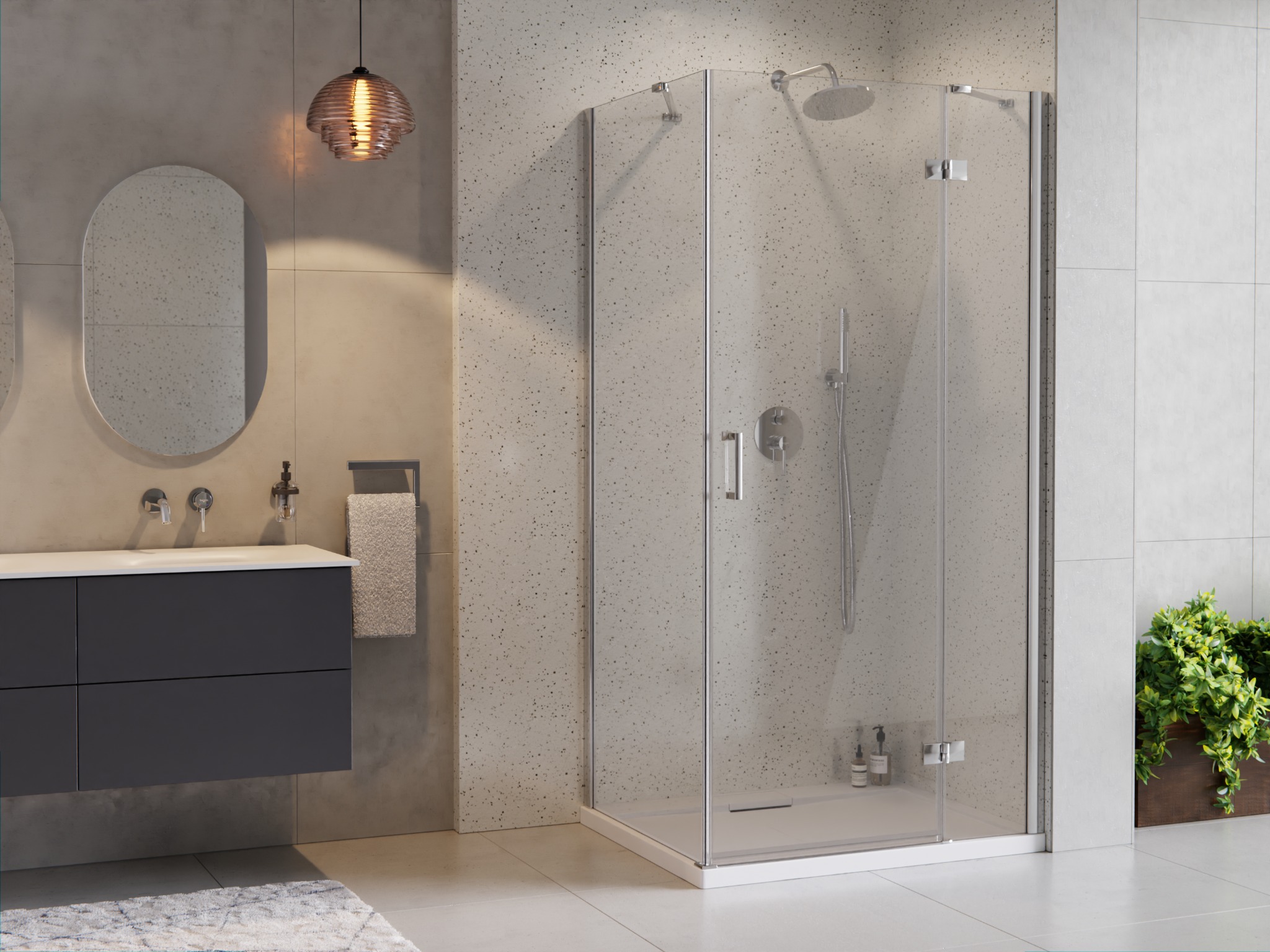 Nowoczesna łazienka z kabiną prysznicową narożną, umywalką z szarą szafką, owalnym lustrem i dekoracyjną lampą wiszącą w tle ściany z drobnymi plamkami.