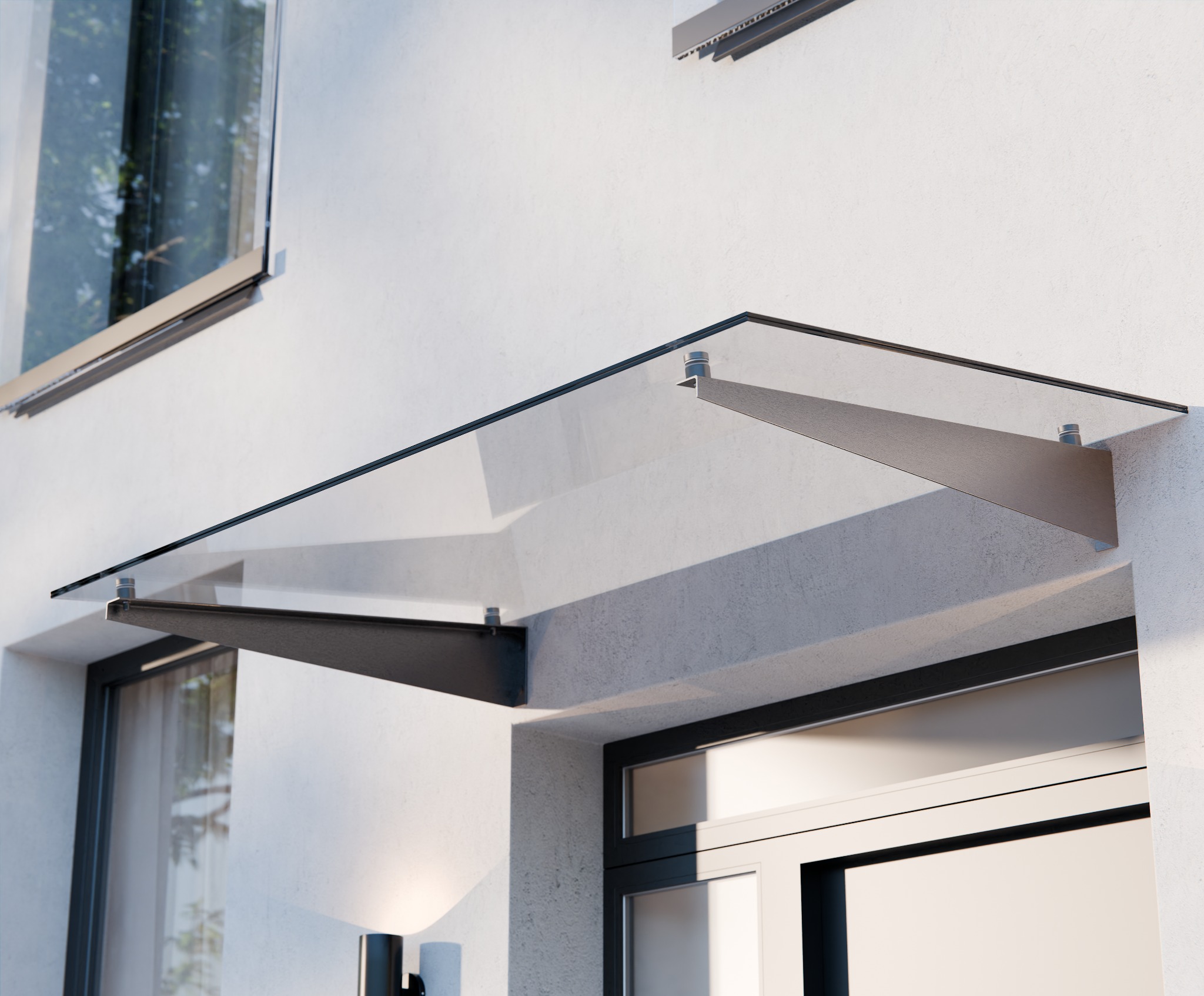 Szklany daszek nad wejściem do budynku, wsparty na metalowych wspornikach, z widocznym fragmentem elewacji i okna.