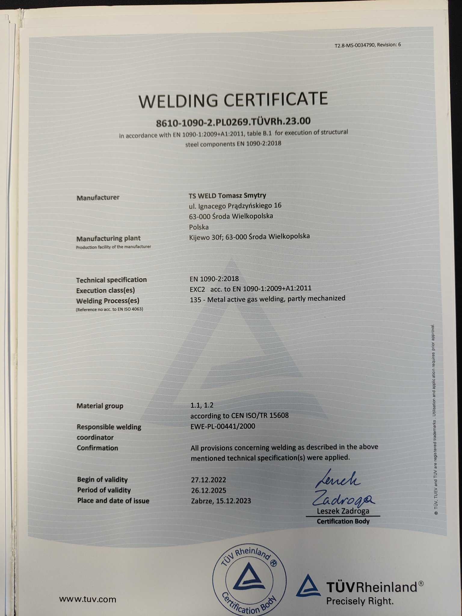 Skan certyfikatu spawalniczego firmy TS WELD Tomasz Smytry, potwierdzający zgodność z normą EN 1090-1:2009+A1:2011 dla konstrukcji stalowych, z pieczątkami TÜV Rheinland i podpisem Leszka Zadrogii.