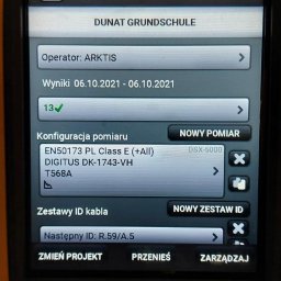 SOLO Dawid Solczak - Ekran miernika Fluke Networks Versiv 2 prezentujący wyniki pomiarów kabli w szkole Dunat Grundschule, z konfiguracją pomiaru EN50173 PL Class E (+All) i identyfikatorem kabla R.59/A.5.
