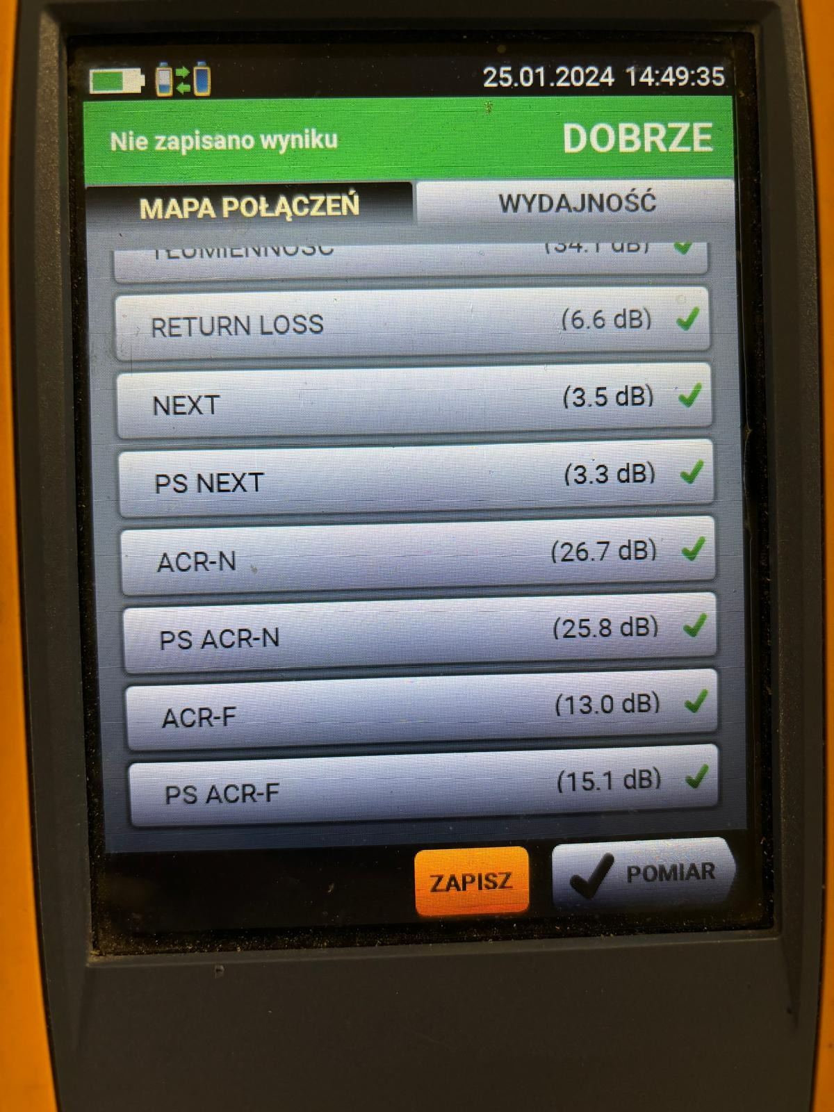 Ekran miernika kabli z wynikami testów połączeń, wskazujący wartości Return Loss, NEXT, ACR-N i inne, wszystkie oznaczone jako 'DOBRZE' z zielonymi znacznikami akceptacji.