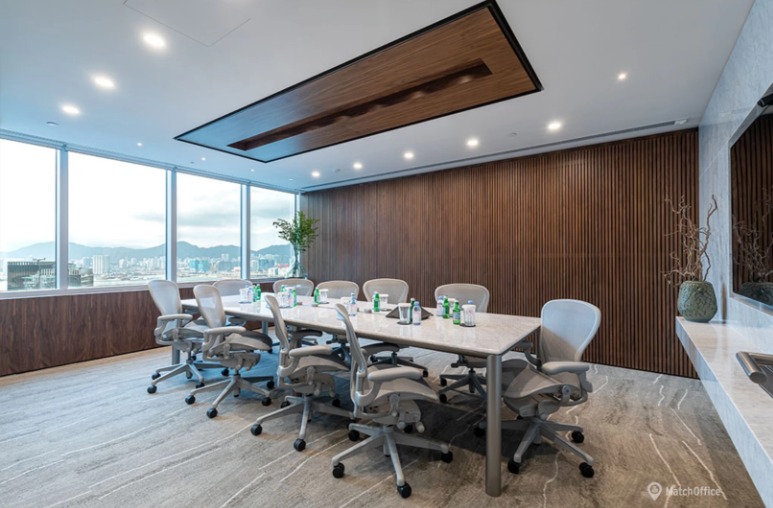 Nowoczesna sala konferencyjna z dużym oknem i widokiem na miasto, marmurowym stołem i szarymi krzesłami biurowymi.