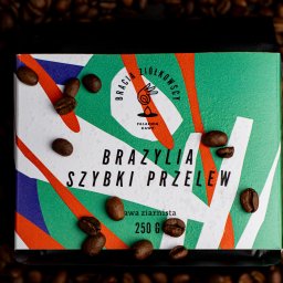 In Boiling Water Company - Paczka kawy ziarnistej Brazylia Szybki Przelew z logo Bracia Ziółkowscy Palarnia Kawy, otoczona ziarnami kawy na ciemnym tle.