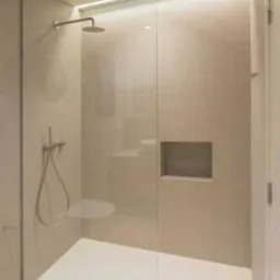 Nowoczesna kabina prysznicowa walk-in z ukrytym oświetleniem LED, wykończona beżowymi płytkami i drewnianą podłogą, z wnęką na kosmetyki.