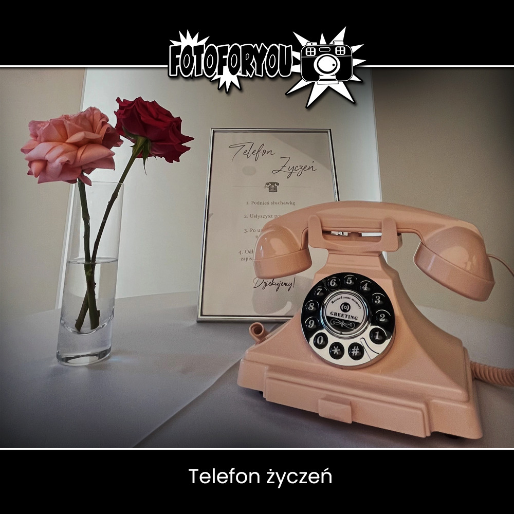 Różowy telefon w stylu retro obok wazonu z różami i ramki z napisem 'Telefon Życzeń', element dekoracyjny na imprezie.