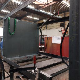 Mobilny Spawacz Jan Bednarczyk Professional Spaw 303 - Konstrukcja metalowa w trakcie spawania w warsztacie w Warszawie. Widoczne narzędzia, profile stalowe i element poszycia. Prace spawalnicze w toku.