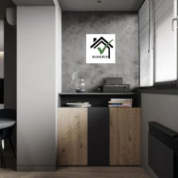 BUDSERVIS SPÓŁKA Z OGRANICZONĄ ODPOWIEDZIALNOŚCIĄ - Wnętrze pokoju z drewnianą podłogą, szafką z drewnianymi frontami, grzejnikiem pod oknem z żaluzjami i logo firmy Budservis na ścianie.