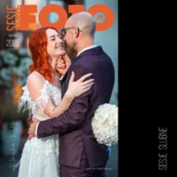 Uśmiechnięta panna młoda z rudymi włosami i pan młody w fioletowym garniturze, trzymający bukiet białych kwiatów podczas sesji ślubnej.