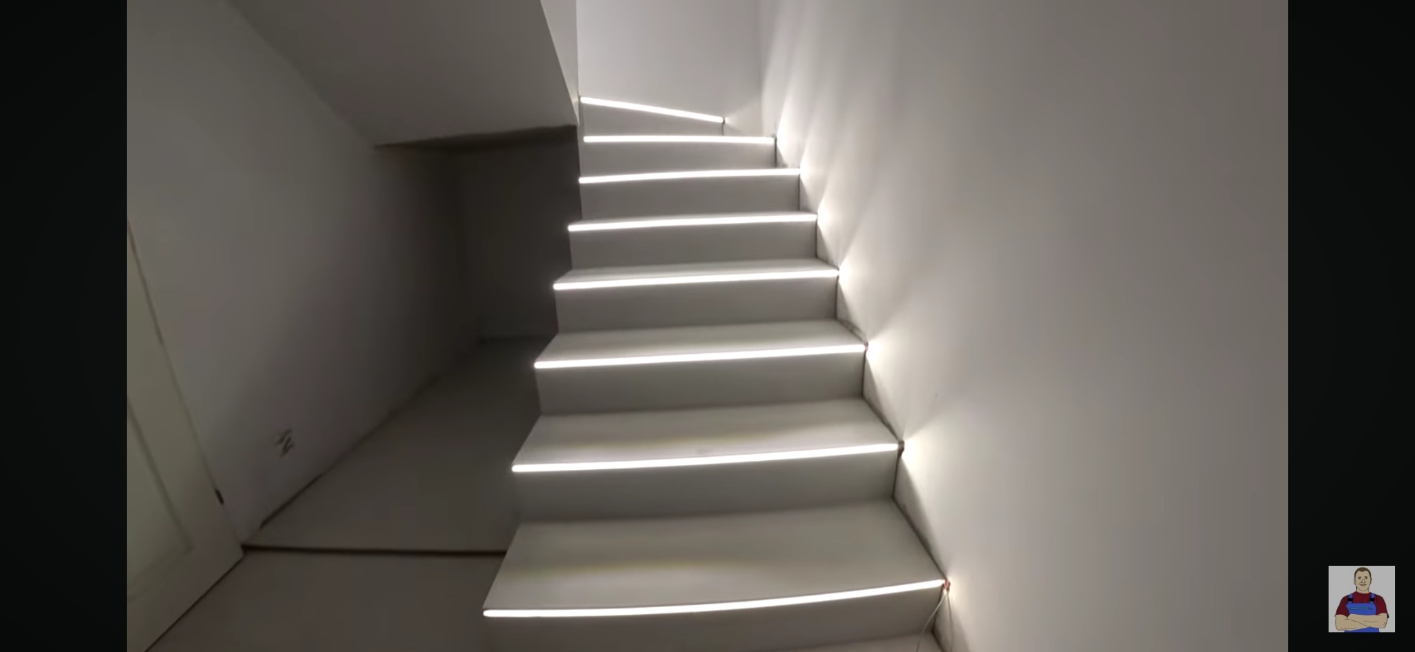 Nowoczesne, białe schody z subtelnym oświetleniem LED na krawędziach stopni, prowadzące w górę w minimalistycznym wnętrzu. Widoczny fragment ściany i podłogi przed schodami.