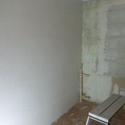 Michał Wesołowski - Ściana po nałożeniu gładzi, widoczna drabina malarska, fragment instalacji hydraulicznej przy narożniku ścian. Jedna ściana wygładzona, druga w trakcie przygotowania do prac wykończeniowych.