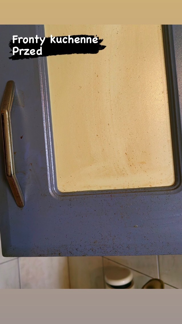 Brudny, kremowy front kuchenny z metalowym uchwytem przed czyszczeniem, widoczne liczne plamy i zabrudzenia, ujęcie z bliska.