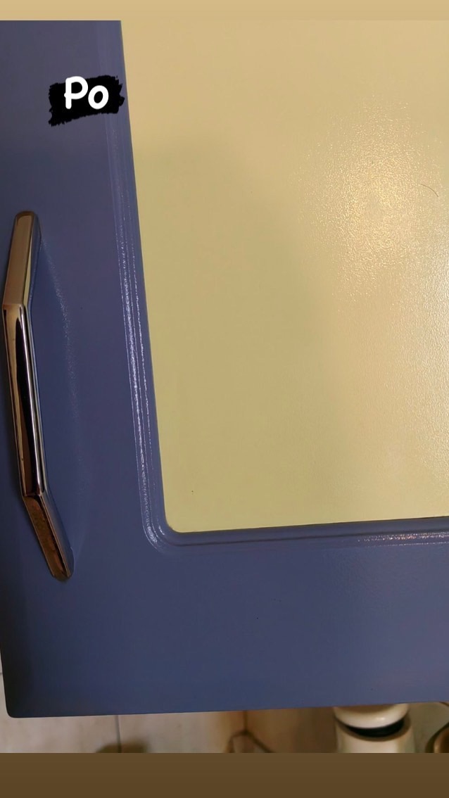 Wykończona, świeżo pomalowana, niebieska szafka z chromowanym uchwytem, widok z bliska po zakończonym malowaniu.