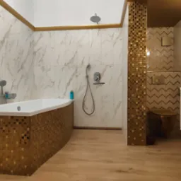 Nowoczesna łazienka z wanną obudowaną mozaiką w odcieniach złota, marmurowe płytki na ścianach z subtelnymi złotymi akcentami, wisząca szafka z umywalką oraz toaleta w kolorze złotym.
