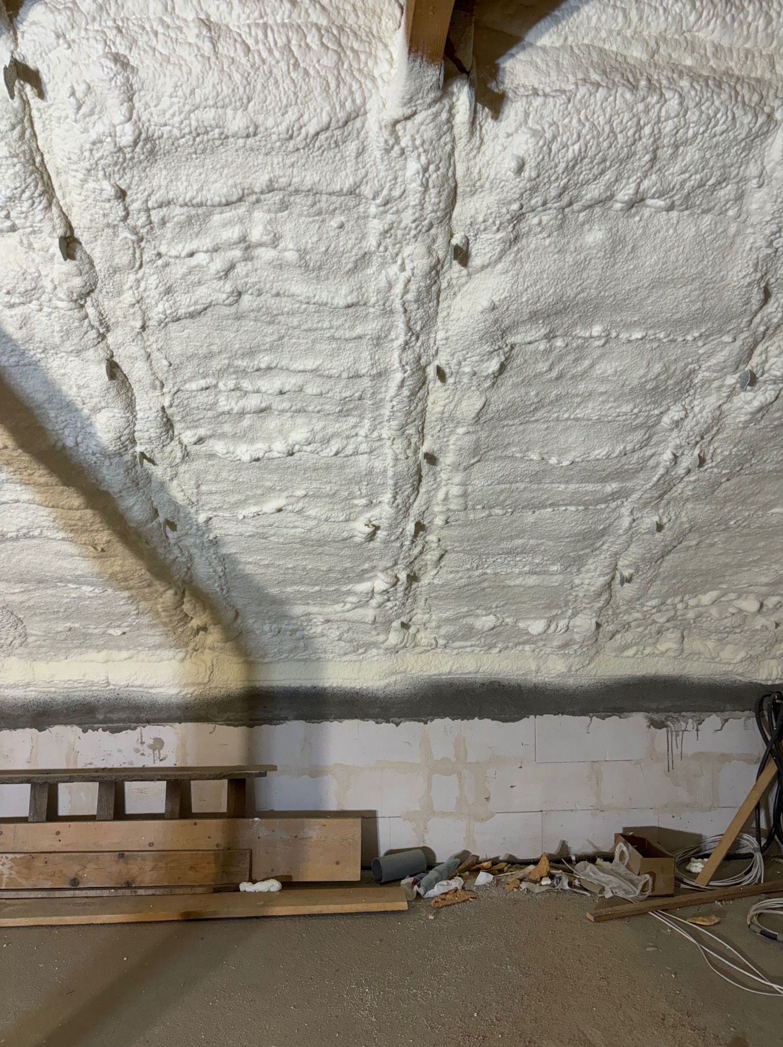 Poddasze w Dąbrowie Tarnowskiej po aplikacji izolacji natryskowej z piany poliuretanowej, widoczne drewniane elementy konstrukcyjne i ślady po montażu.