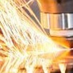 LOGISERV GROUP SPÓŁKA Z OGRANICZONĄ ODPOWIEDZIALNOŚCIĄ SPÓŁKA JAWNA - Intensywny strumień iskier podczas obróbki metalu, prawdopodobnie cięcia, z widocznym fragmentem maszyny i obrabianego elementu.