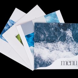 Zenga Print - Stos menu SPA & Wellness z motywami wody i natury, ułożonych wachlarzowo na czarnym tle, z widocznym logo.