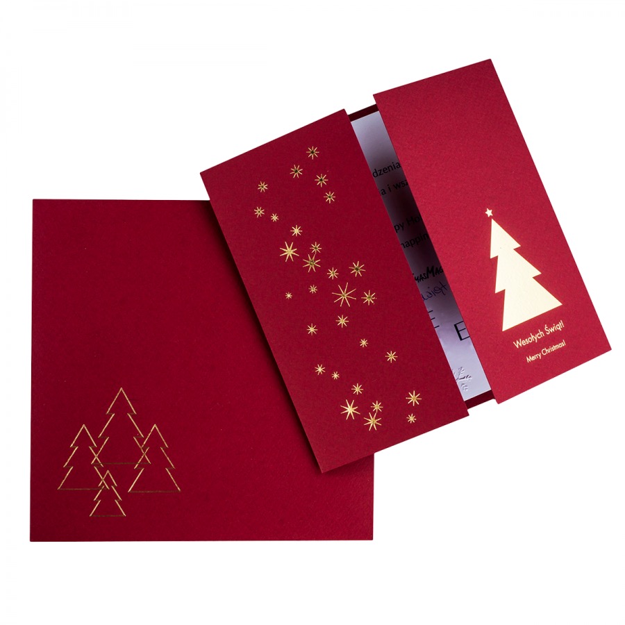Czerwona kartka świąteczna z motywem złotych choinek i gwiazd, częściowo otwarta, ukazująca treść życzeń.