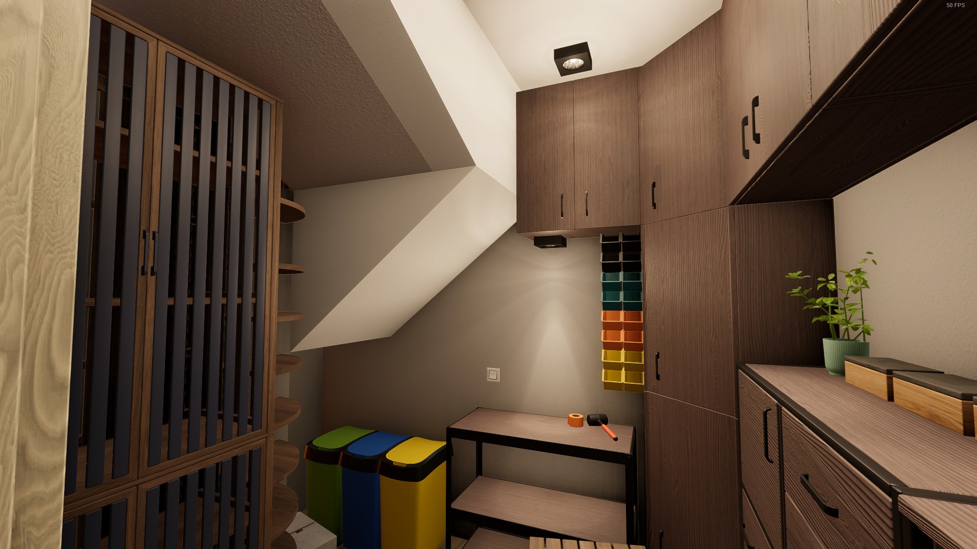 Wnętrze garderoby na poddaszu ze skośnym sufitem, zabudowa z drewnianymi szafkami, sortownikiem na ścianie, biurkiem z narzędziami i kolorowymi koszami na śmieci.