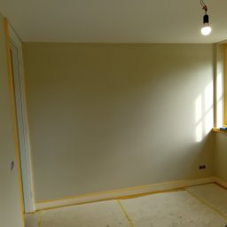 Robert BARTNIK - Pokój przygotowany do malowania: ściany zabezpieczone taśmą malarską, podłoga zakryta folią ochronną, widoczne gniazdko elektryczne i okno z parapetem, na którym leżą narzędzia malarskie.