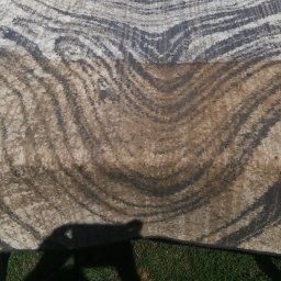 PHU MICHAŁ Michał Maciszewski - Dywan z wzorem w paski, częściowo wyczyszczony, leżący na zewnątrz w Zielonej Górze, obok żółtego odkurzacza piorącego.