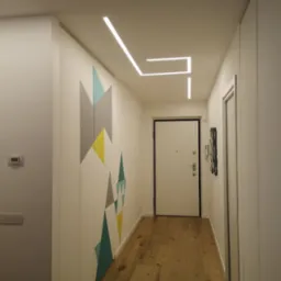 Nowoczesny przedpokój z zabudową szafy z geometrycznym wzorem, drewnianą podłogą i liniowym oświetleniem LED na suficie.